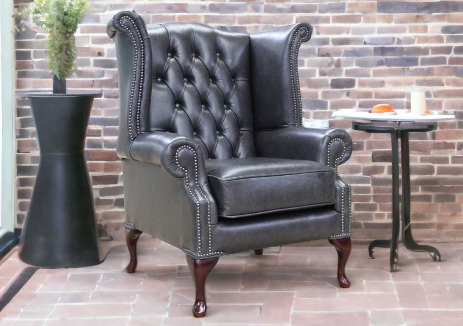 Product photograph of Chesterfield Queen Anne High Back Wing Chair Cracked Wax Black Leather from Designer Sofas 4U